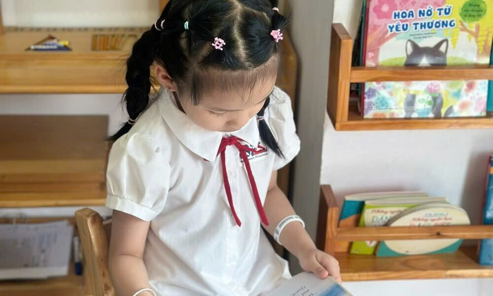 Hình ảnh bé đọc sách ở góc thư viện